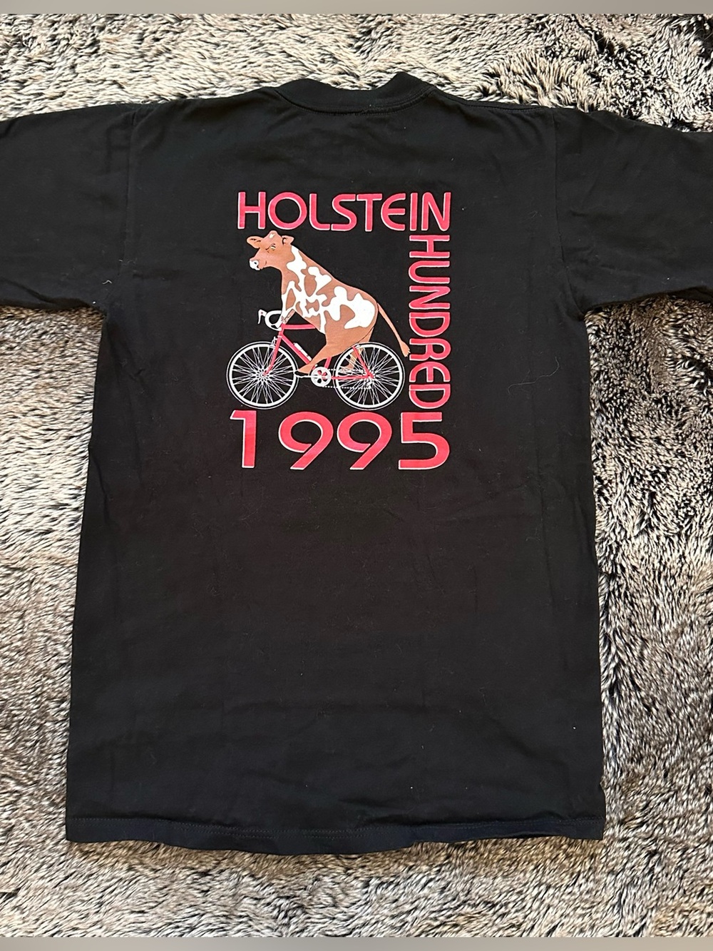 Black cotton t-shirt with graphic of a cow riding a bicycle